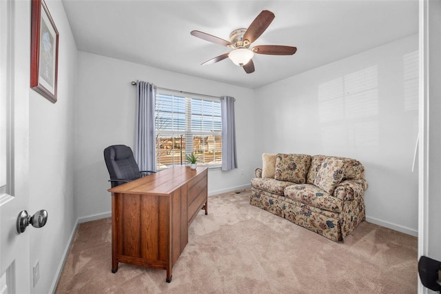 home office with light carpet, a ceiling fan, and baseboards