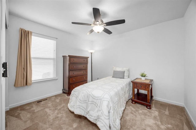 bedroom featuring light colored carpet, visible vents, ceiling fan, and baseboards