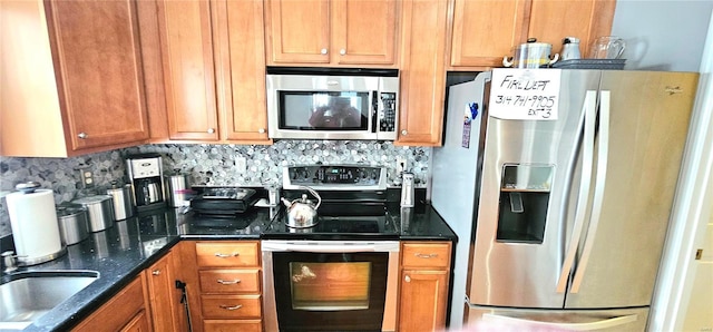 kitchen with tasteful backsplash, sink, stainless steel appliances, and dark stone counters