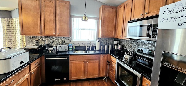 kitchen featuring sink, backsplash, stainless steel appliances, dark hardwood / wood-style flooring, and decorative light fixtures