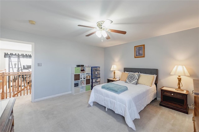 bedroom with light colored carpet, ceiling fan, and baseboards