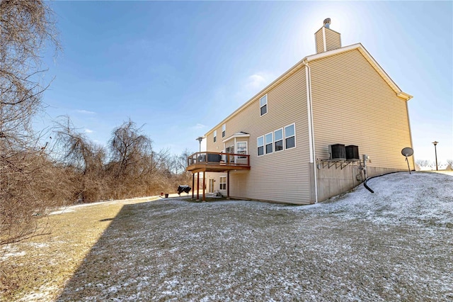 rear view of property with a chimney and a wooden deck