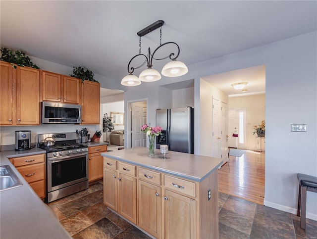 kitchen featuring stainless steel appliances, stone finish flooring, decorative light fixtures, and a kitchen island