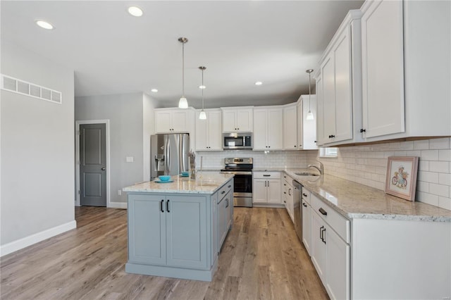 kitchen with decorative backsplash, white cabinets, stainless steel appliances, and visible vents
