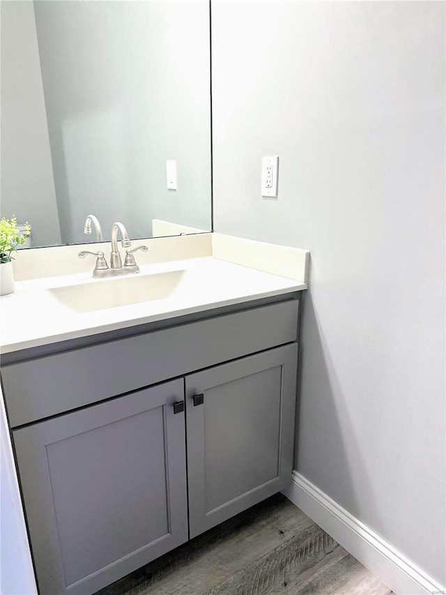 bathroom with vanity, baseboards, and wood finished floors