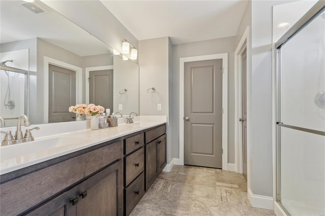 full bath with a sink, baseboards, a shower stall, and visible vents