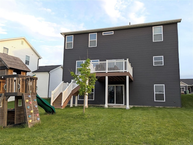 back of property featuring a playground, a wooden deck, a yard, and stairway