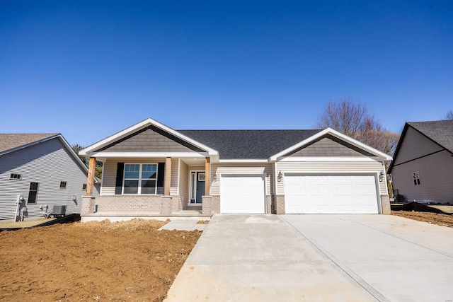 view of front of property featuring driveway, a garage, cooling unit, and brick siding