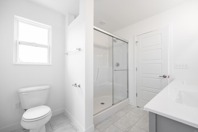 bathroom featuring marble finish floor, double vanity, toilet, a shower stall, and baseboards