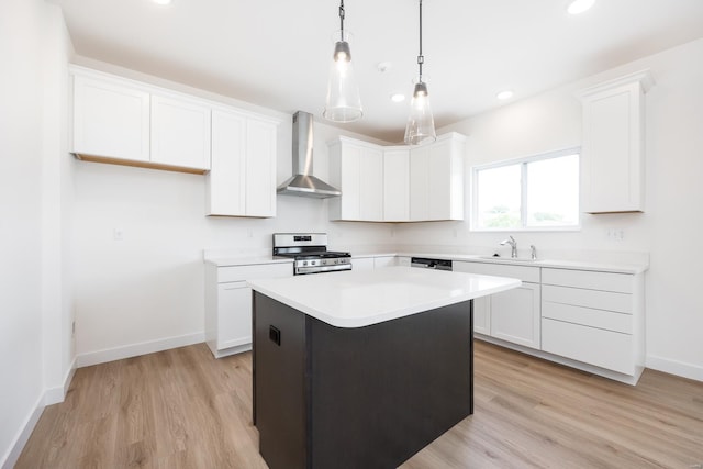 kitchen with white cabinets, wall chimney exhaust hood, appliances with stainless steel finishes, and light countertops