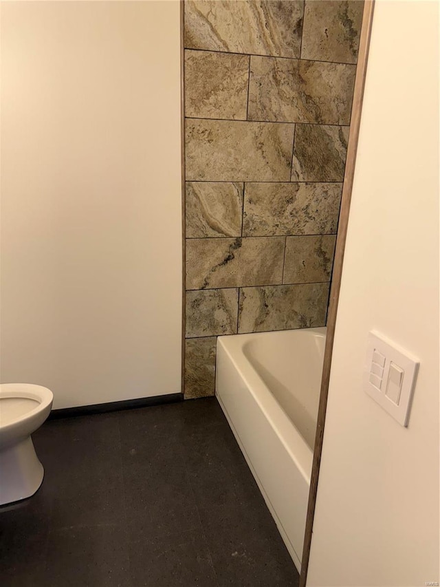 bathroom with a tub to relax in and toilet