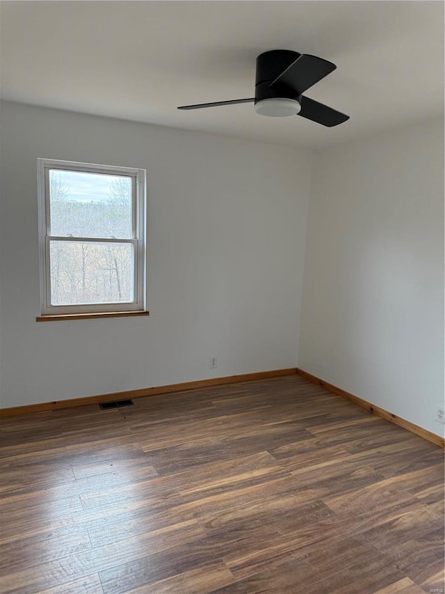 spare room featuring dark wood-type flooring and ceiling fan