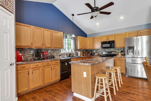 kitchen featuring a breakfast bar area, hanging light fixtures, dark hardwood / wood-style floors, a center island, and black appliances