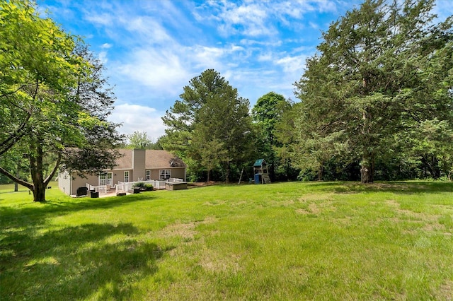 view of yard featuring a wooden deck and a playground