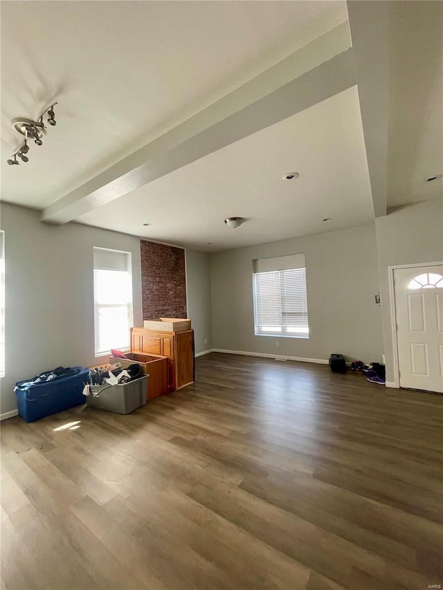 unfurnished living room featuring hardwood / wood-style flooring and track lighting