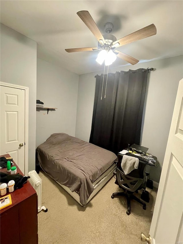 bedroom featuring radiator heating unit, ceiling fan, and carpet