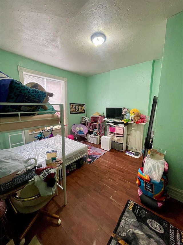 bedroom with wood-type flooring and a textured ceiling