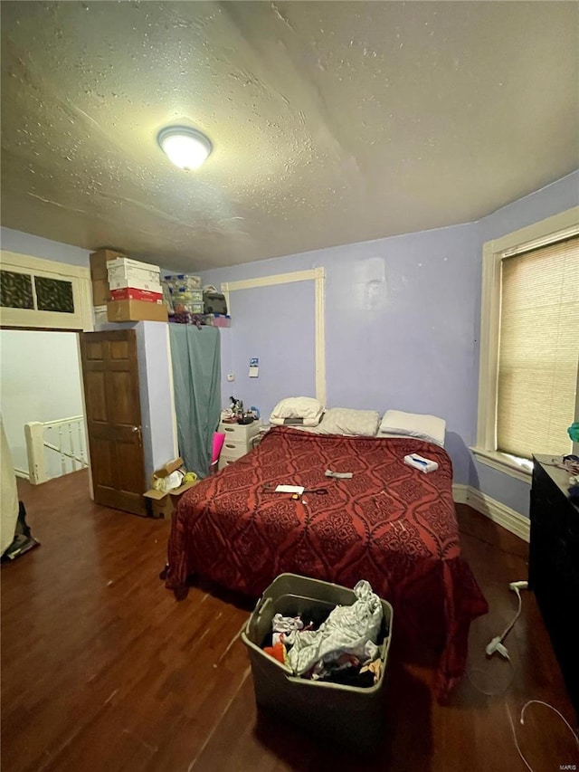 bedroom with dark wood-type flooring and a textured ceiling