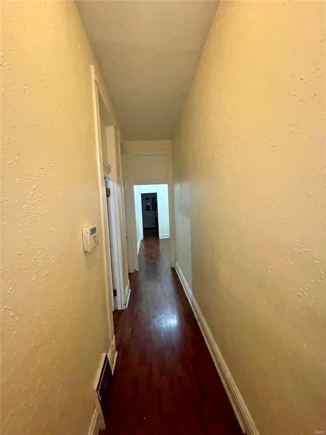 hallway with dark hardwood / wood-style flooring