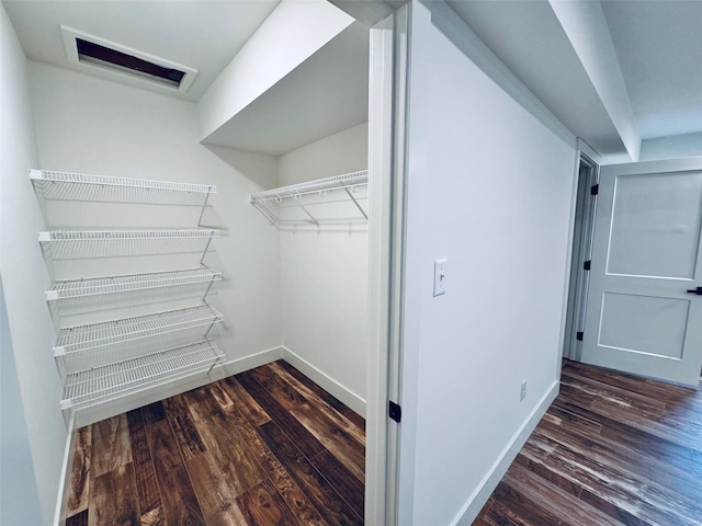 spacious closet with dark wood finished floors and visible vents