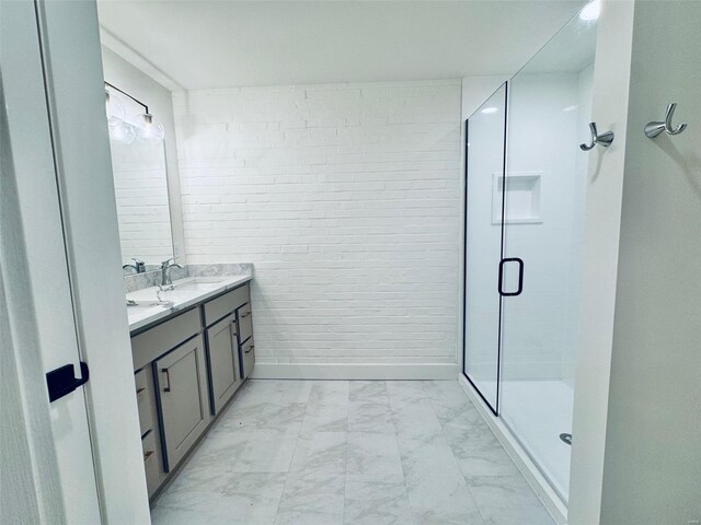 bathroom with double vanity, a stall shower, baseboards, marble finish floor, and a sink