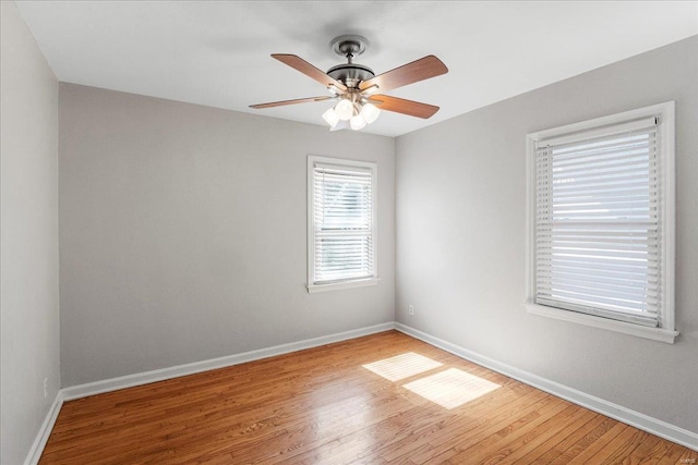 unfurnished room with a ceiling fan, baseboards, and wood finished floors