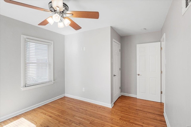 unfurnished room with light wood-type flooring, baseboards, and a ceiling fan