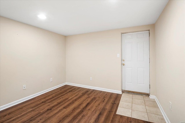 unfurnished room featuring baseboards and wood finished floors