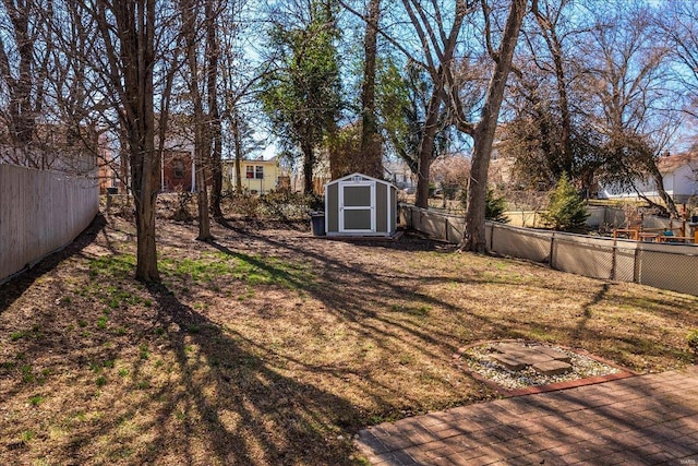 view of yard with a storage unit, an outbuilding, and a fenced backyard