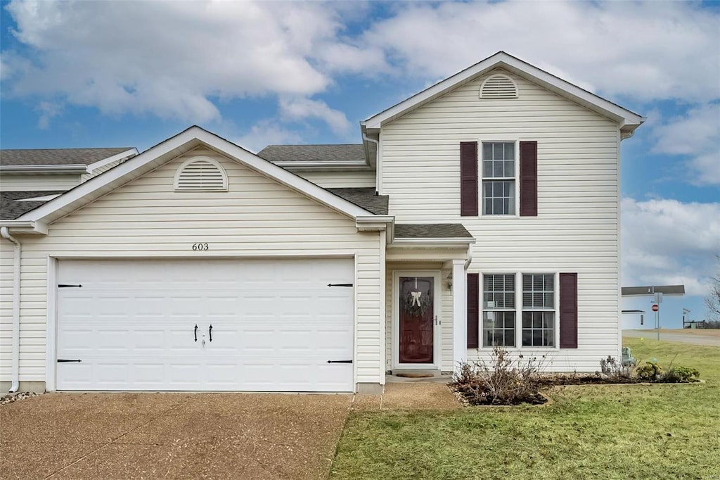 view of front of home with a garage and a front lawn