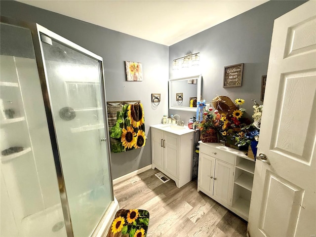 bathroom featuring hardwood / wood-style flooring, vanity, and an enclosed shower