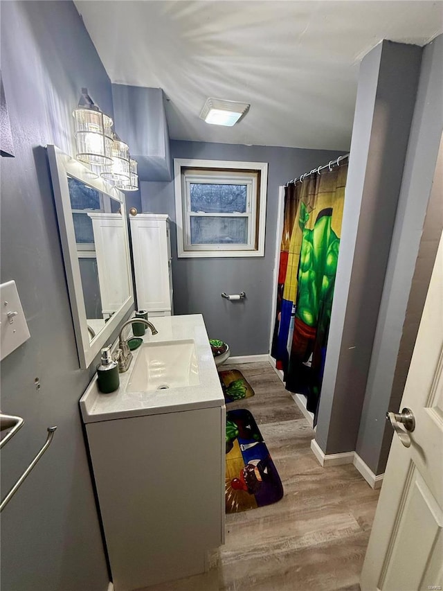 bathroom with hardwood / wood-style flooring, vanity, curtained shower, and toilet