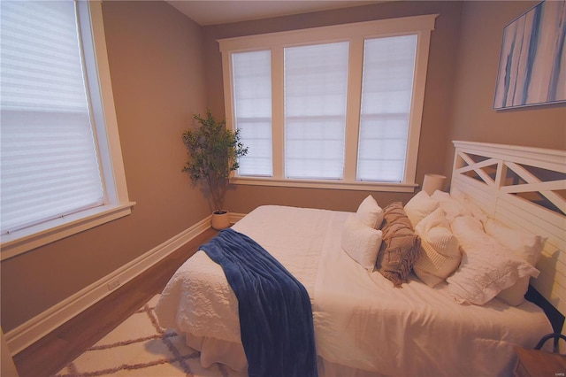 bedroom featuring wood finished floors and baseboards