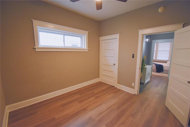 unfurnished bedroom with a ceiling fan, baseboards, and wood finished floors