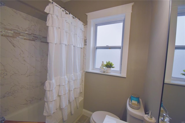 full bathroom featuring toilet, shower / bath combo, and baseboards