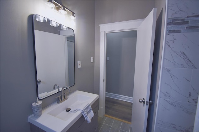 bathroom with vanity, baseboards, and wood finished floors