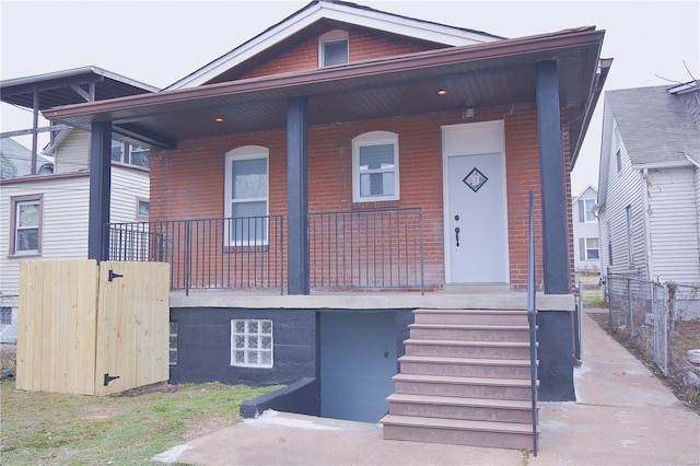 view of front of home featuring covered porch and brick siding