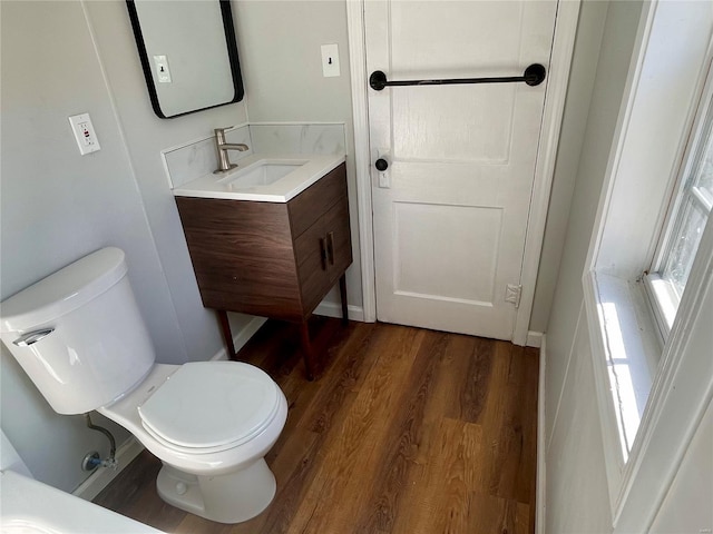 bathroom featuring toilet, wood finished floors, and vanity