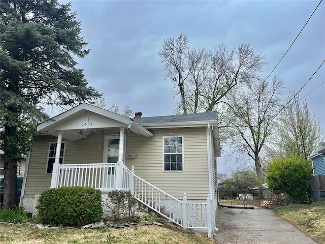 bungalow with covered porch and fence
