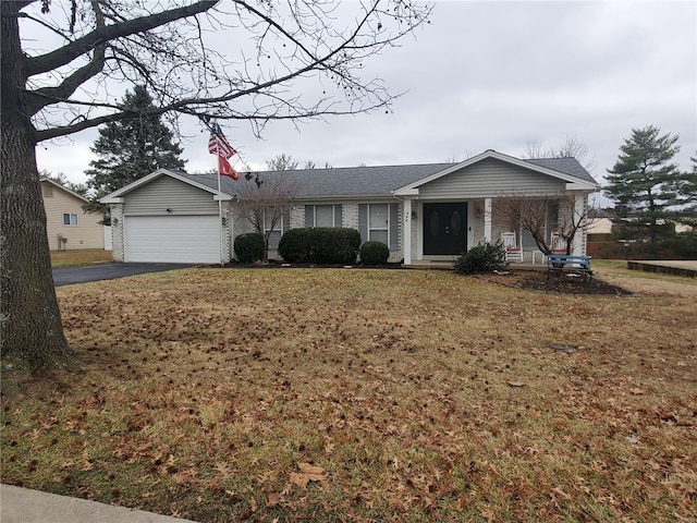 ranch-style house with covered porch, a front yard, and a garage