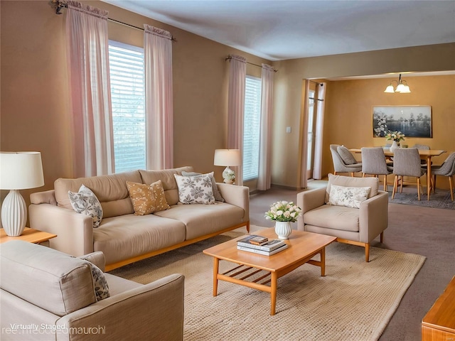 living room with a notable chandelier, carpet floors, and a wealth of natural light