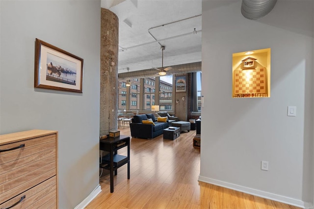 hallway featuring baseboards and wood finished floors