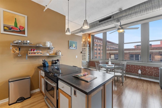 kitchen with visible vents, light wood-style floors, electric stove, dark countertops, and decorative light fixtures