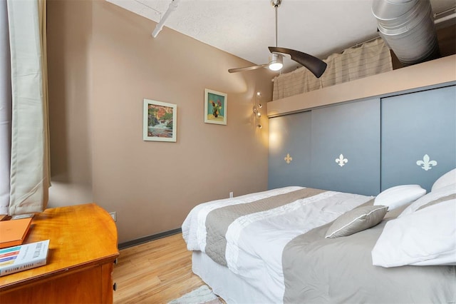 bedroom with a ceiling fan, a closet, baseboards, and light wood finished floors