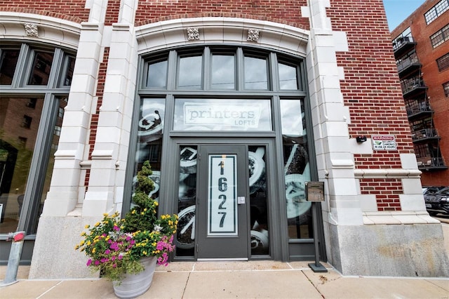 entrance to property featuring brick siding