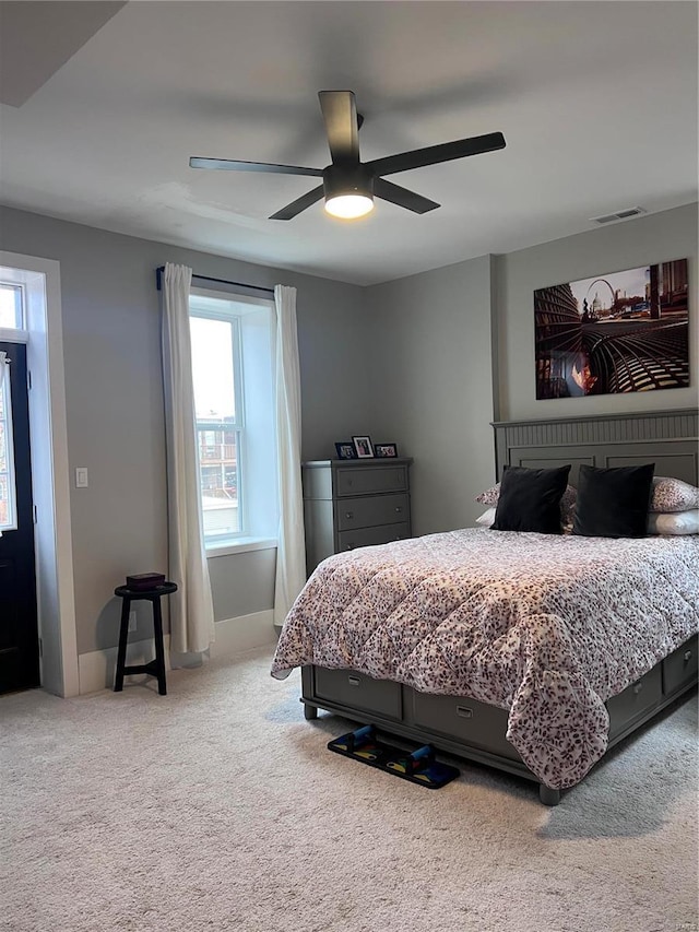 bedroom featuring carpet, multiple windows, visible vents, and a ceiling fan