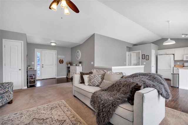 carpeted living area with baseboards, wood finished floors, a ceiling fan, and vaulted ceiling