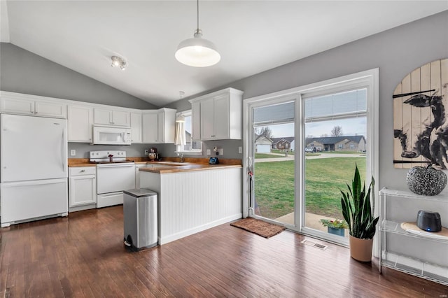 kitchen featuring white appliances, dark wood finished floors, a peninsula, hanging light fixtures, and white cabinets