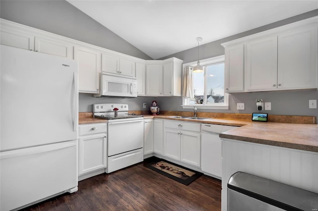 kitchen with white appliances, a sink, vaulted ceiling, dark wood-type flooring, and white cabinetry