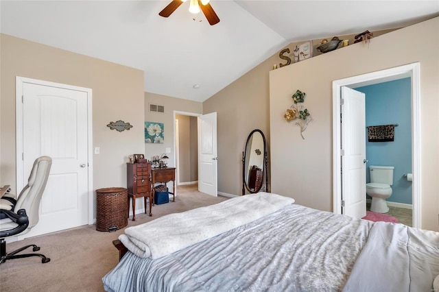 bedroom featuring visible vents, baseboards, lofted ceiling, carpet floors, and ensuite bath